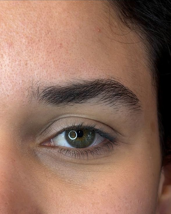 Sobrancelha de cliente com olhos verdes, vista de perto